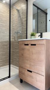a bathroom with a shower and a wooden vanity with a sink at Casa Paz en Benajarafe in Benajarafe
