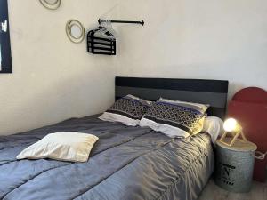 a bedroom with a bed with pillows and a lamp at SP570-A101 Appartement 2 pièces - balcon - parking - Saint Pierre la mer in Saint Pierre La Mer