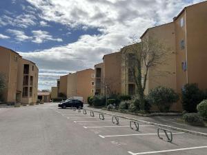 a car parked in a parking lot next to buildings at SP570-A101 Appartement 2 pièces - balcon - parking - Saint Pierre la mer in Saint Pierre La Mer