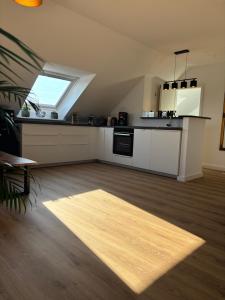 a kitchen with white cabinets and a window at Zentrale Lage, kostenlos Parken, ideal für Pendler, Kinder und Haustiere willkommen!! in Kaarst