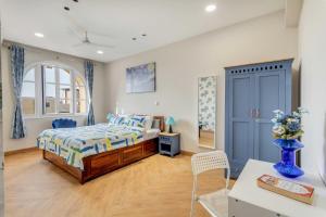 a bedroom with a bed and a blue cabinet at Aqua 2 BHK Apartment by tisyastays in Candolim +21 photos