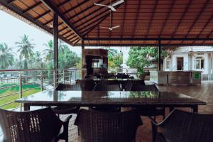 a restaurant with a large table and chairs at Tinton Adventure Resort in Golikatte