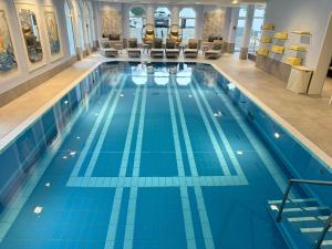 巴特诺因阿尔-阿尔韦勒曙光别墅私人酒店的建筑物内铺有蓝色瓷砖的大型游泳池