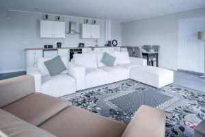 a living room with white couches and a kitchen at Ridgeway Retreat - 1 Bedroom Cottage - Manorbier in Manorbier