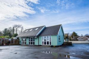 a blue building with a roof on a parking lot at Ridgeway Retreat - 1 Bedroom Cottage - Manorbier in Manorbier