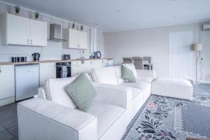a living room with white furniture and a kitchen at Ridgeway Retreat - 1 Bedroom Cottage - Manorbier in Manorbier +13 photos