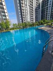 a large swimming pool in a city with tall buildings at Riqqa Cove Splash Mania Homestay in Banting +10 photos