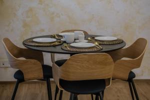 a black table with plates and cups and chairs at Apartmán v srdci Prahy in Prague