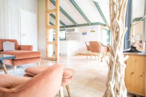 a living room with orange chairs and a table at Hol(t)z Hus in Born