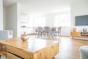 Una sala de estar con una mesa y sillas y un televisor. en Jade 2, en Born