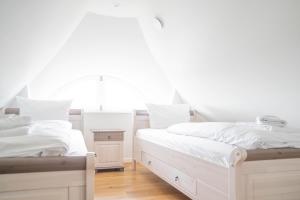 Dos camas blancas en una habitación con ventana. en Jade 2, en Born