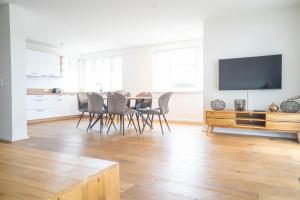 Una sala de estar con una mesa y sillas y un televisor. en Jade 4, en Born
