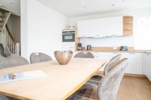 Una cocina con una mesa y sillas de madera. en Jade 4, en Born