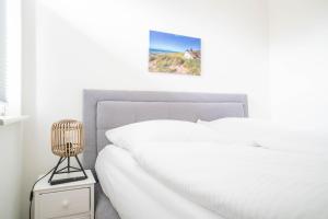 Un dormitorio con una cama blanca y un cuadro en la pared. en Jade 4, en Born