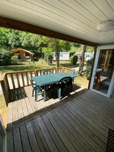 a patio with a table and chairs on a deck at Camping L Eden Road in Castellane