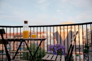 a table with a bottle of orange juice and flowers on a balcony at Acogedores apartamentos en el centro in Alcantarilla