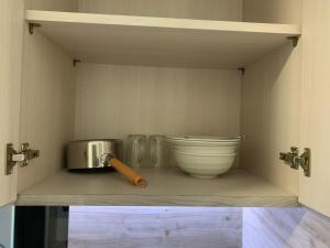 a kitchen shelf with a mortar and pestle and a bowl at Comfortstay - Citra Plaza Nagoya #31-08 Sea View in Jodoh