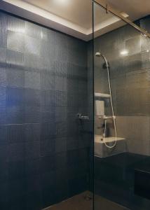 a shower with a glass door in a bathroom at De Prime Rangnam Hotel in Bangkok +49 photos