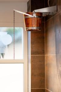 a metal bucket hanging from the ceiling in a bathroom at M&V Resort Camping in Langrune-sur-Mer