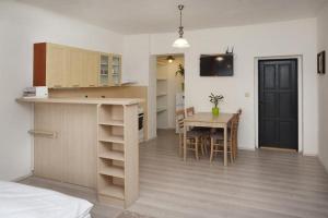 a kitchen and dining room with a table and a kitchen and a room at Aparthotel Brokeš in Lanškroun