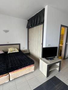 チェルノモレツにあるRelaxing apartment - 100 meters from the seaのベッドと薄型テレビのある寝室