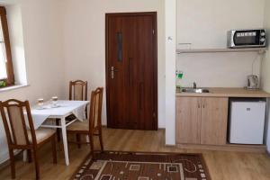a kitchen with a table and chairs and a kitchen with a sink at Agroturystyka Jeroniczówka in Choroszcz