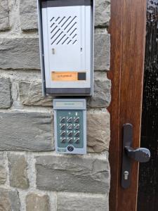 un teléfono público al lado de una pared de ladrillo en Le Plein Sud, en Stoumont