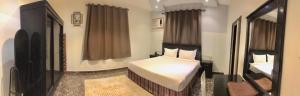 a bedroom with a bed and a mirror at شقق سما التميز للشقق المخدومة in Khamis Mushayt