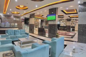 a lobby with blue couches and a tv at شقق سما التميز للشقق المخدومة in Khamis Mushayt