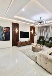 a living room with a couch and a flat screen tv at 2 Bedroom Luxe Haven Apartment Ikoyi Lagos in Lagos