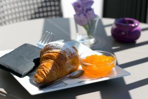 a plate with a loaf of bread and a bowl of orange sauce at The Purple Hotel - Adults Only in San Antonio
