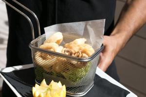 a person holding a basket with food in it at The Purple Hotel - Adults Only in San Antonio