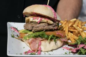 a hamburger and french fries on a white plate at The Purple Hotel - Adults Only in San Antonio