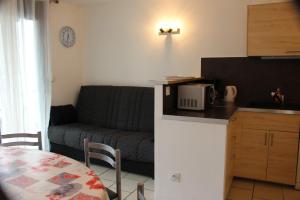 a kitchen and a living room with a couch and a table at Bel appartement au pied des pistes 9 personnes in Saint-Lary-Soulan