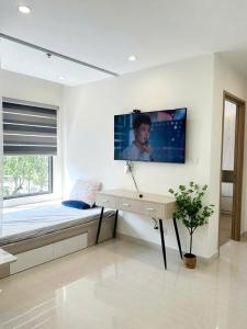 ein Schlafzimmer mit einem Bett, einem Schreibtisch und einem Fernseher in der Unterkunft Shi House -2BR Bulding S903- Netflix & Balcony Q9 in Long Bình