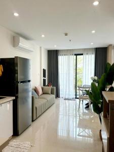 eine Küche und ein Wohnzimmer mit einem Sofa und einem Kühlschrank in der Unterkunft Shi House -2BR Bulding S903- Netflix & Balcony Q9 in Long Bình