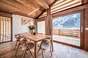 ein Esszimmer mit Tisch und Stühlen und einem großen Fenster in der Unterkunft Chalet Foxden, Les Houches Chamonix - by EMERALD STAY in Les Houches