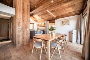 eine Küche und ein Esszimmer mit einem Holztisch und Stühlen in der Unterkunft Chalet Foxden, Les Houches Chamonix - by EMERALD STAY in Les Houches