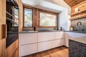 eine Küche mit weißen Schränken und einem Fenster in der Unterkunft Chalet Foxden, Les Houches Chamonix - by EMERALD STAY in Les Houches + 38 Fotos