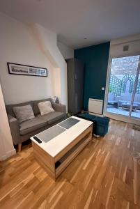 a living room with a bed and a couch at Cosy Appartement Levallois-Perret in Levallois-Perret