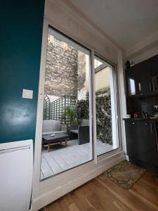 a kitchen with a sliding glass door to a patio at Cosy Appartement Levallois-Perret in Levallois-Perret