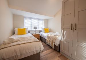 a bedroom with two beds and a window at Olive Lodge Lytham in Lytham St Annes