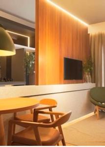 a kitchen with a table and chairs and a television at Luxuoso e Aconchegante Ed Jh Palhano 1108 in Londrina