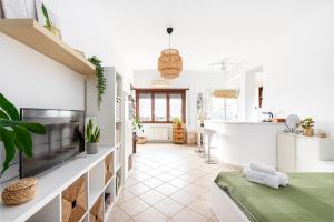 a kitchen and living room with white walls and a fireplace at Tiny Boho Chic in Lido di Ostia