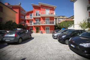 a parking lot with cars parked in front of a building at Villa Lucia in Caorle