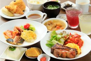 藤沢市にあるEN HOTEL Fujisawaの食べ物や飲み物の皿が置かれたテーブル