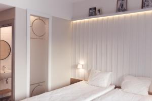 una camera bianca con 2 letti e uno specchio di Rannahotell a Pärnu