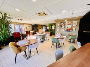 a restaurant with tables and chairs in a room at Campanile Montargis - Amilly in Amilly