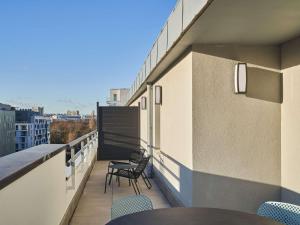 a balcony with chairs and tables on a building at ibis budget Issy Les Moulineaux Paris Ouest in Issy-les-Moulineaux