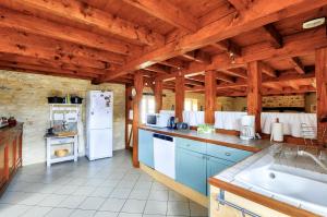 eine Küche mit weißen Geräten und Holzdecken in der Unterkunft Maison en pierre au pied de La Vézère, pour 6 in Saint-Léon-sur-Vézère